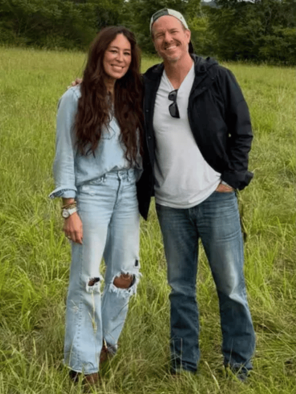 Joanna and Chip Gaines standing together in a grassy field