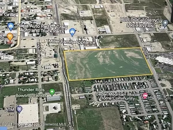 Aerial map showing a yellow-outlined vacant parcel beside W 5th Street in Craig.