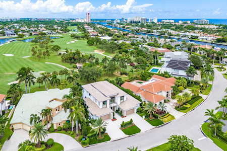 Aerial view of East Boca homes beside a golf course, with waterways and the coastline beyond.