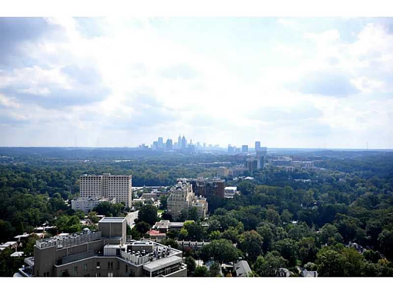 Atlanta skyline rising beyond a tree-covered cityscape.