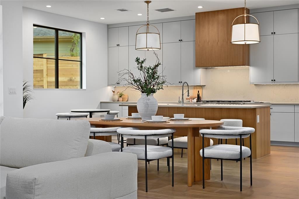 Kitchen and dining area at 2635 Barton Hills Dr, Austin, with wood-accent cabinetry, an island, and pendant lighting.