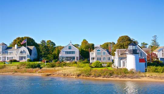 Coastal homes line the Hyannis shore above blue water.