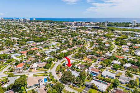 Aerial view of East Boca homes, with a red arrow marking a location and the ocean on the horizon.