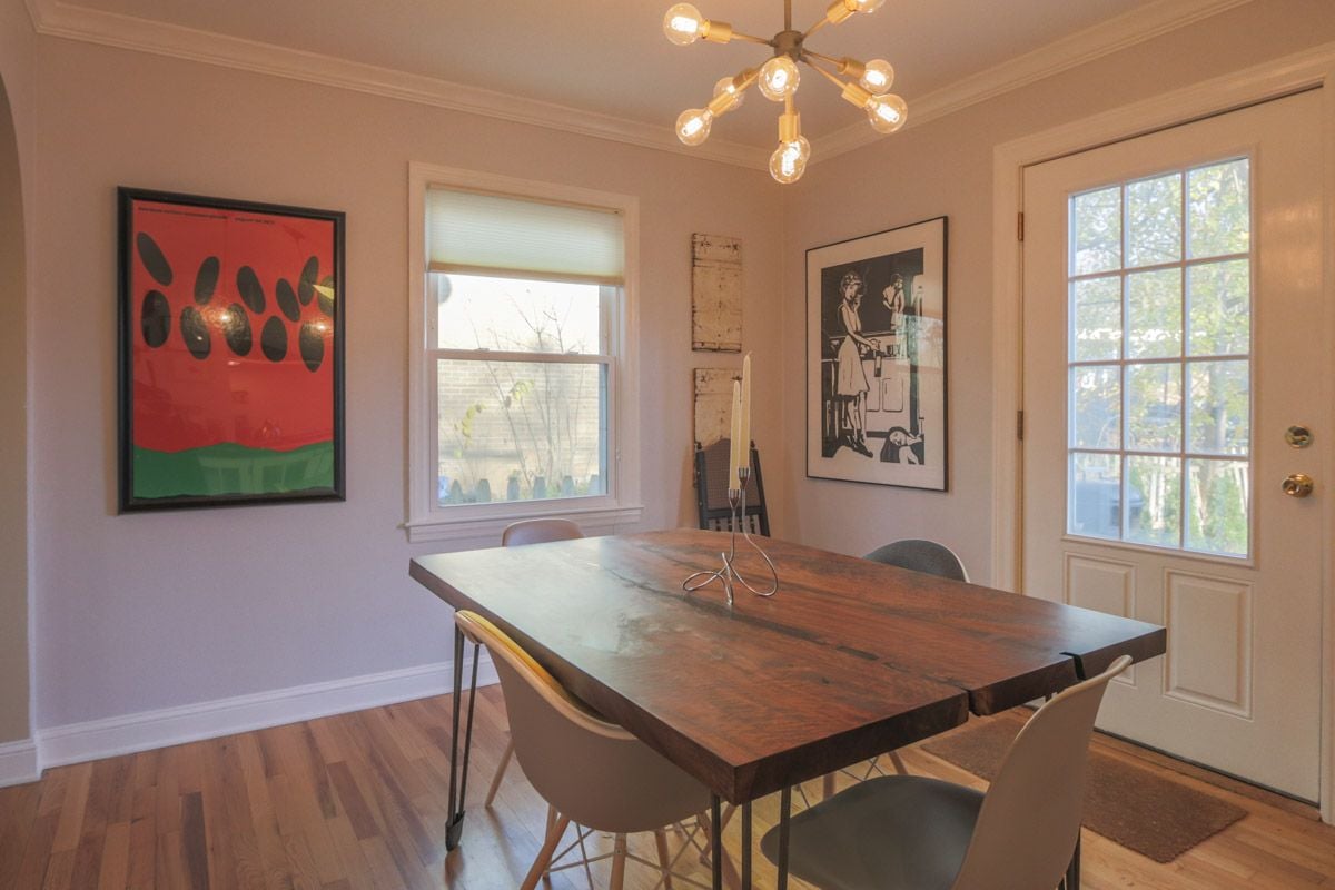 Dining room with a live-edge wooden table, modern chairs, and a starburst chandelier.