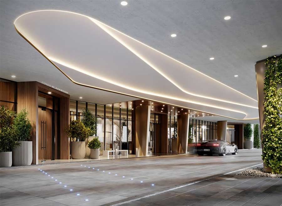 Tal Aventura entrance beneath a sweeping illuminated canopy, with landscaped planters and a car at the drop-off.