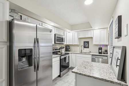 Modern kitchen with white cabinetry, stainless steel appliances, and a granite-topped island.