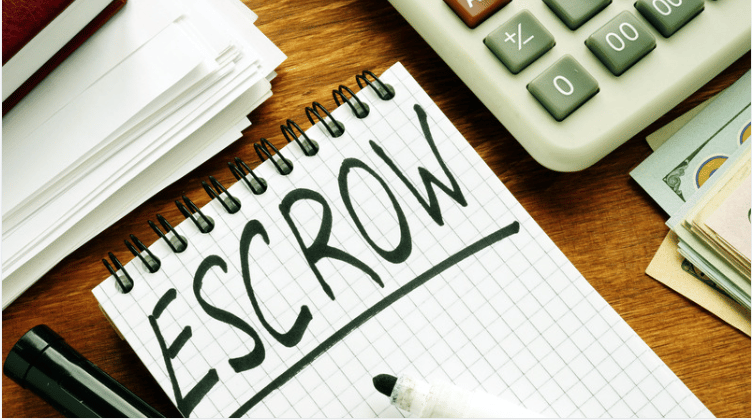 Notebook labeled “ESCROW” beside a calculator, paperwork, cash, and a pen.