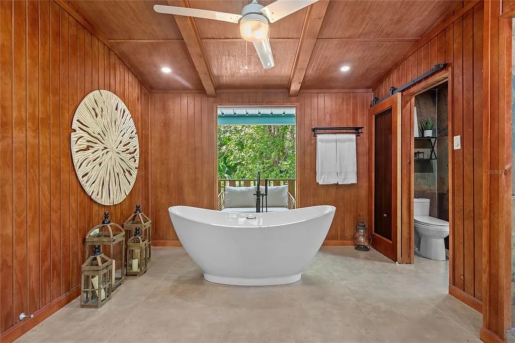 Freestanding bathtub in wood-paneled bathroom