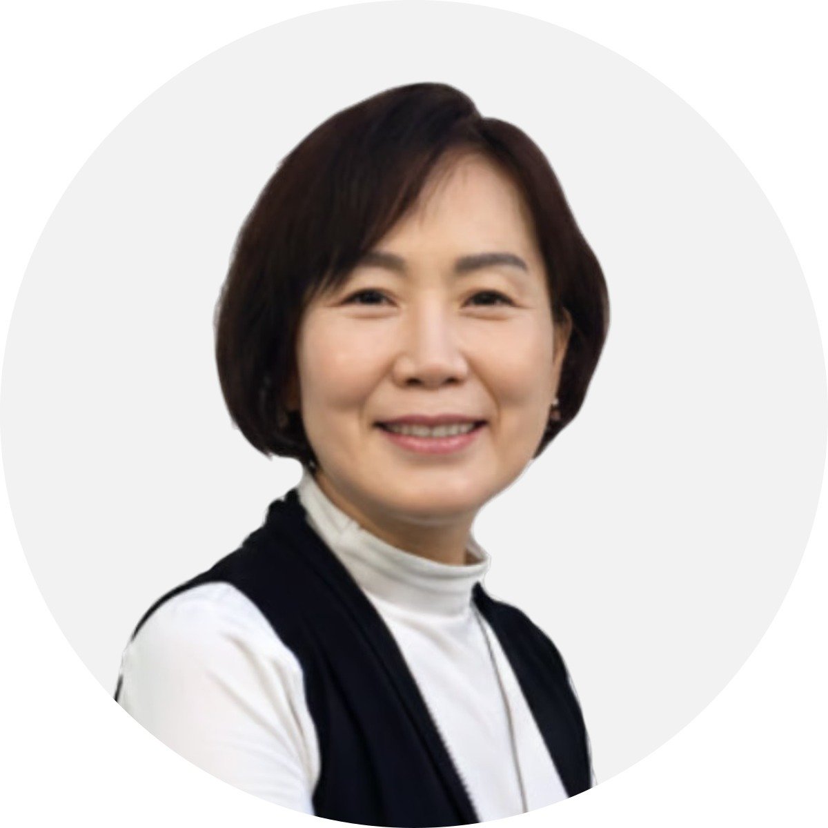 Rebecca Kim, smiling in a white turtleneck and black vest.