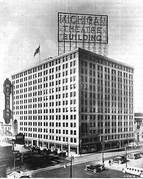 Michigan Life Building with rooftop signage, a corner sign, and vintage cars on the surrounding streets.
