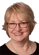 Margaret-Ann Ashburn smiling in burgundy glasses and a black top.