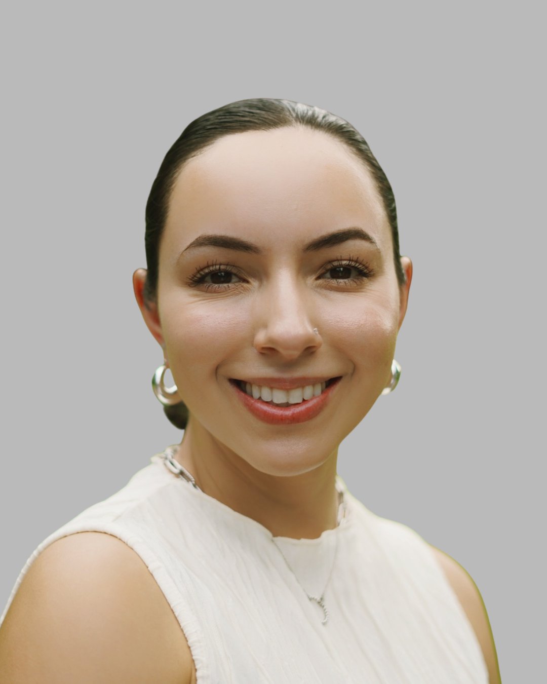 Kimberly Orellana smiling in a white sleeveless top and hoop earrings.