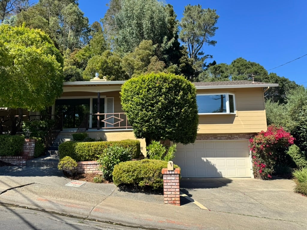 Front view of 235 Mountain View Avenue, a two-bedroom Dominican home for sale in San Rafael with a large yard and pool.