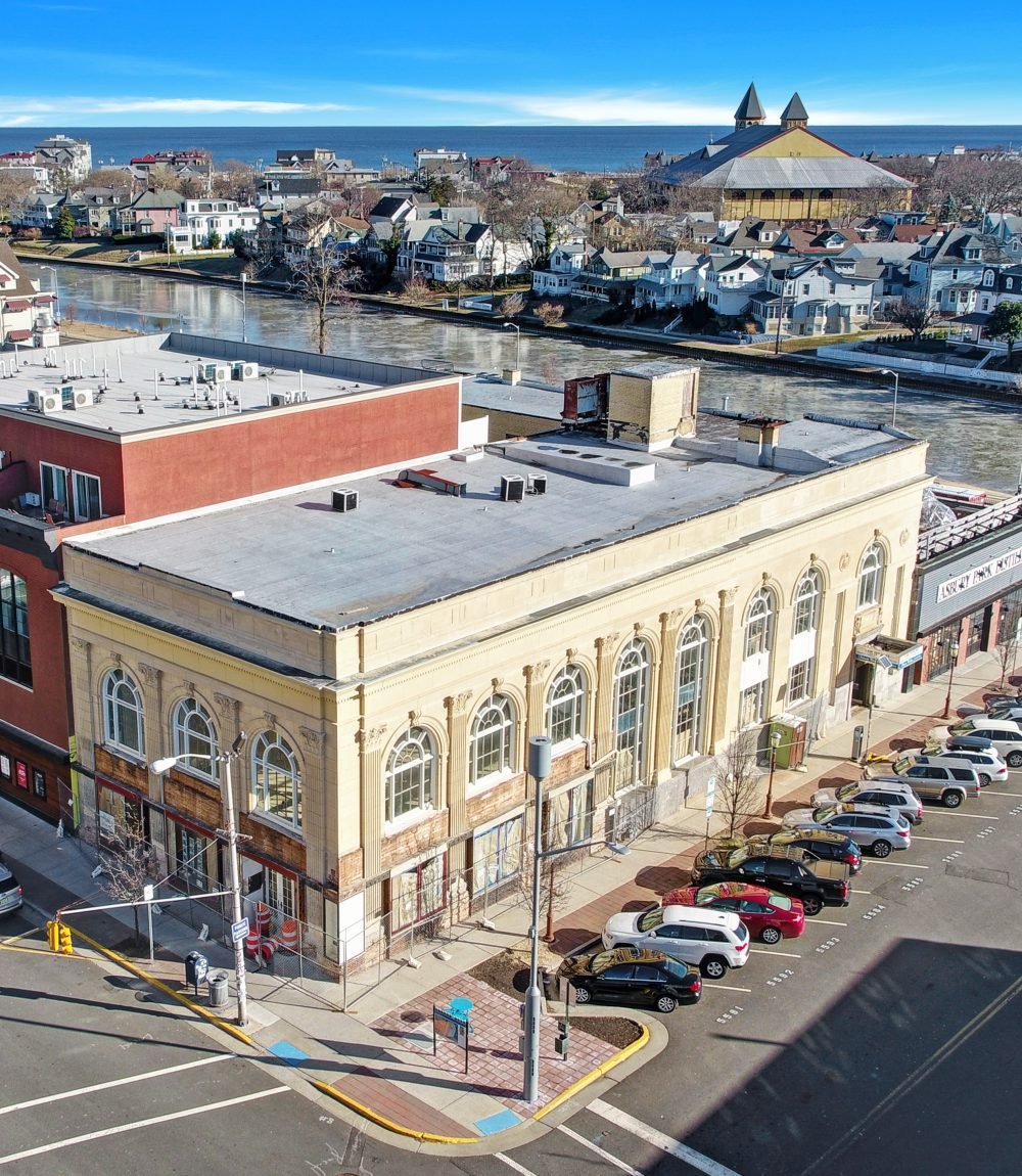 Aerial view of 574 Cookman Avenue, a historic commercial building with arched windows near the ocean.