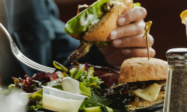 A hearty burger and fresh salad being enjoyed, perfect for a casual meal at Aspen Colorado restaurants.