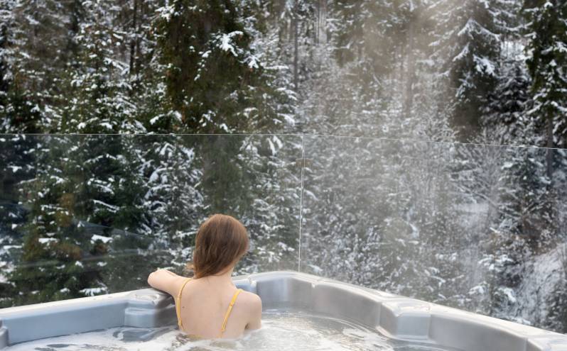 Enjoy mountain views from a steamy hot tub at your Aspen vacation home rental during a winter escape.