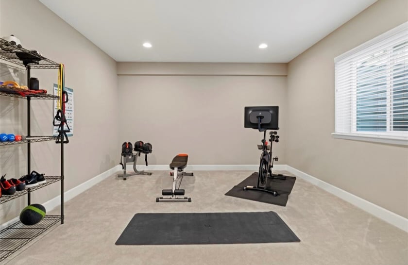 Luxurious fully finished basement home theater with tiered recliners, surround sound, and dimmed lighting in Castle Rock ranch home.