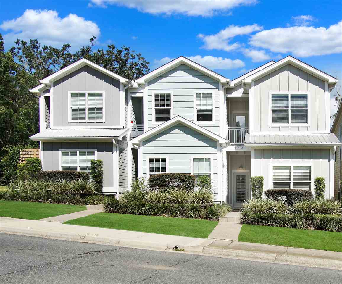 Two-story townhouses featuring white siding complemented by blue trim, showcasing a charming residential design.