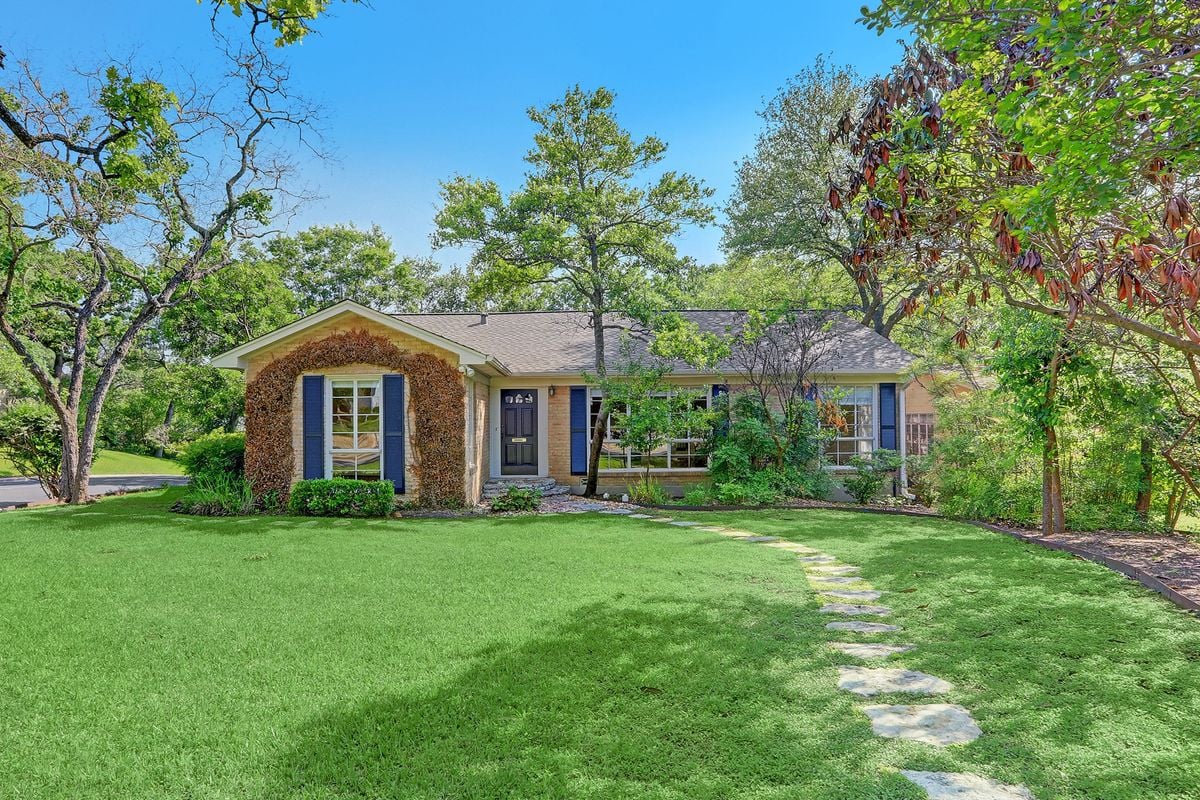 Midcentury ranch brick front elevation with mature oak trees at 2601 Westover Road in Austin's Tarrytown neighborhood.