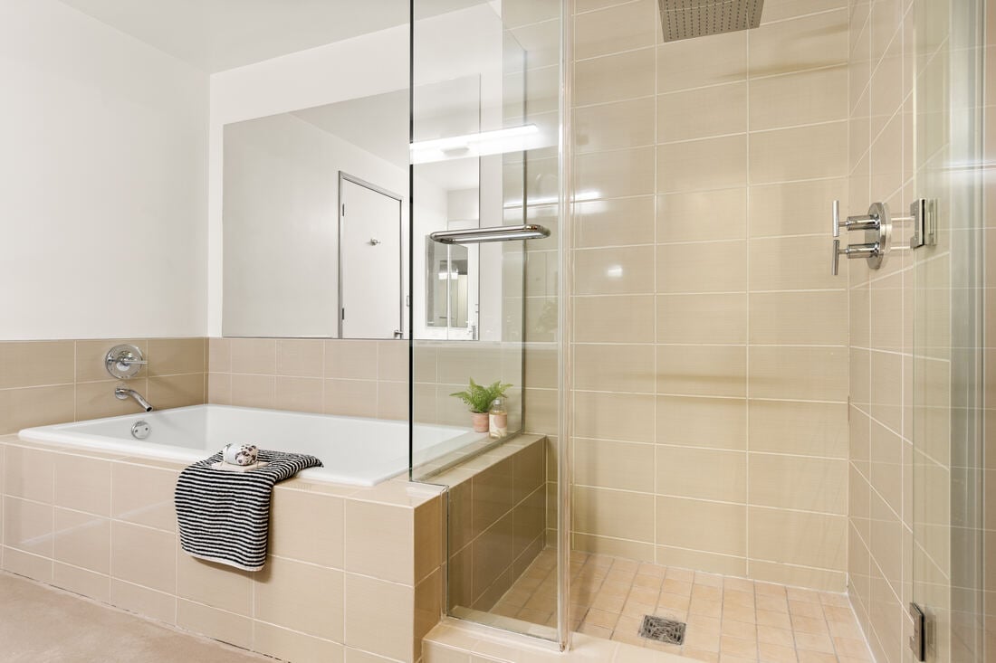 Secondary suite bath with deep soaking tub and glass rain shower