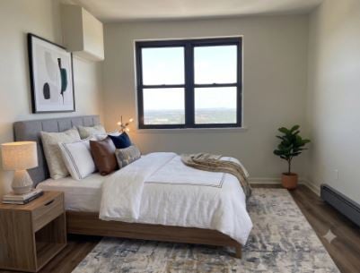 Virtually staged living area at 201 12th Street Unit 19, Palisades Park, open to the kitchen, with a sliding door to the balcony and a wall air conditioning unit