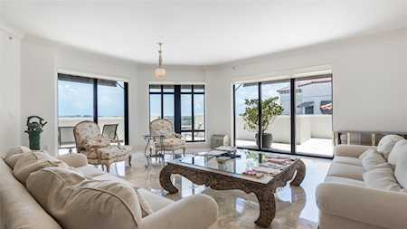 Bright living room with cream seating, an ornate coffee table, and large windows opening to a terrace.