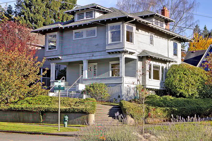 Photograph of a stately four-square home set up off the street