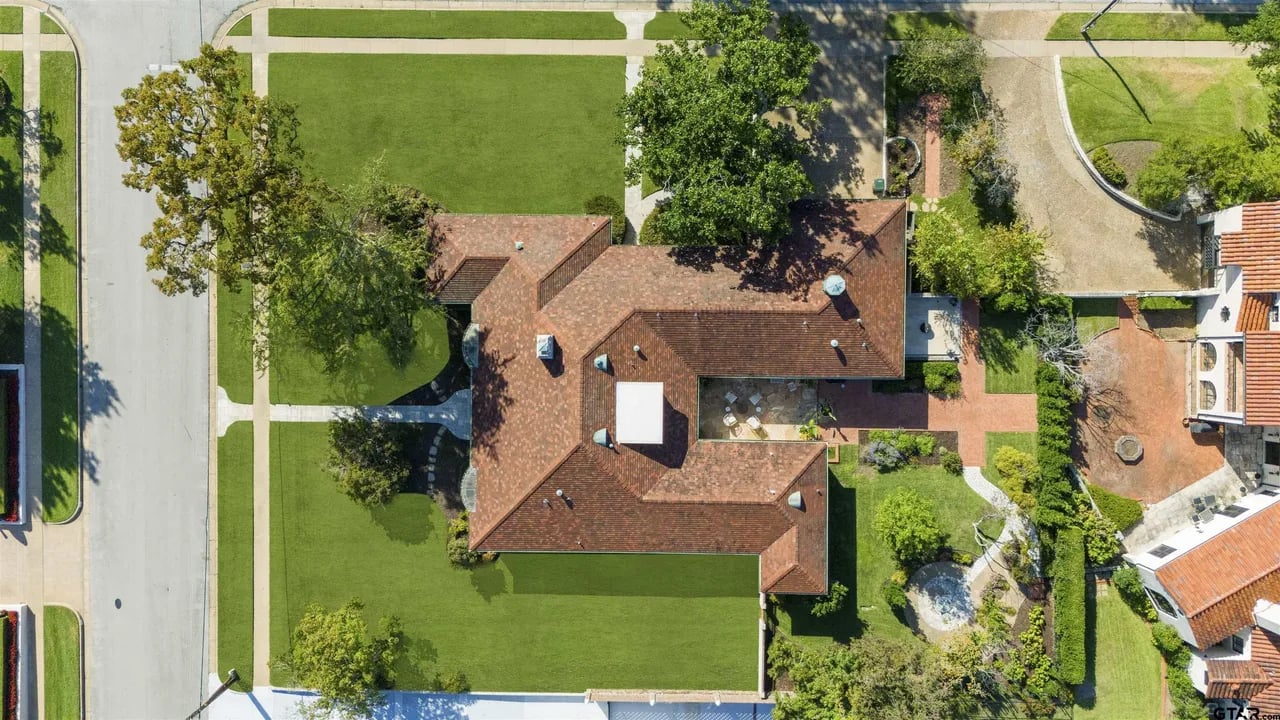 aeriel image taken from drone of overhead view on house with red tile roof and green grass