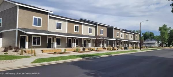 Attached two-story townhomes with covered porches lining a street in Craig.