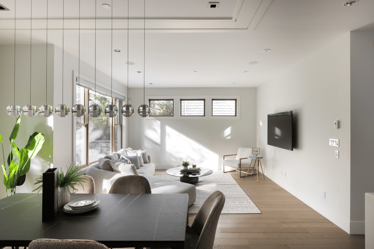 A modern luxury home interior featuring a sleek dining area, large windows, and natural lighting.