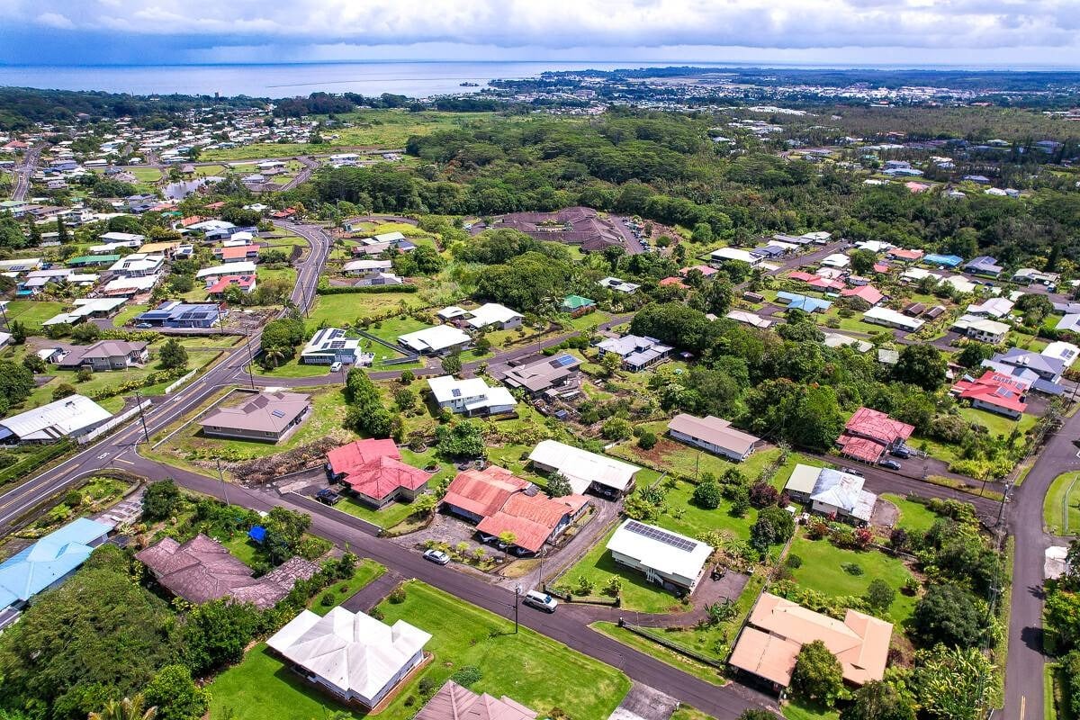 Aerial view of Hilo homes and winding streets, with the bay in the distance.