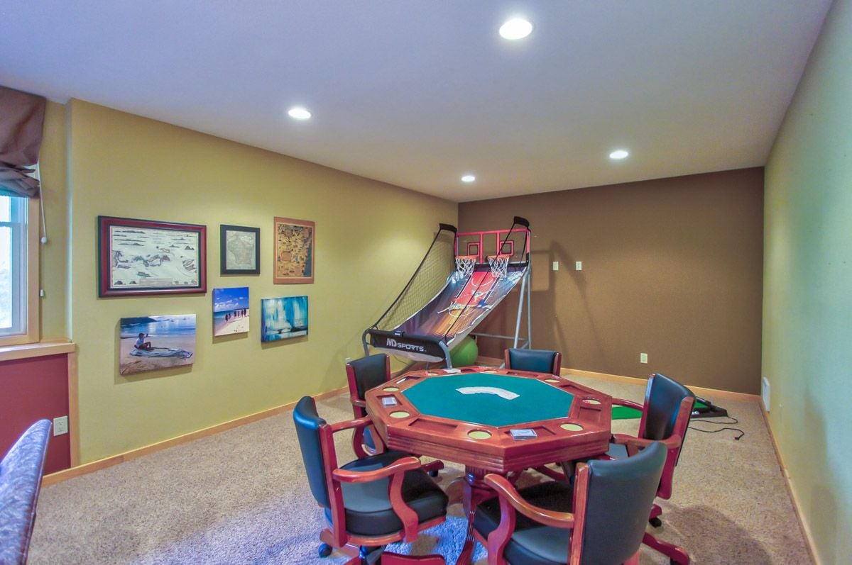 Recreation room with a poker table and basketball arcade game.