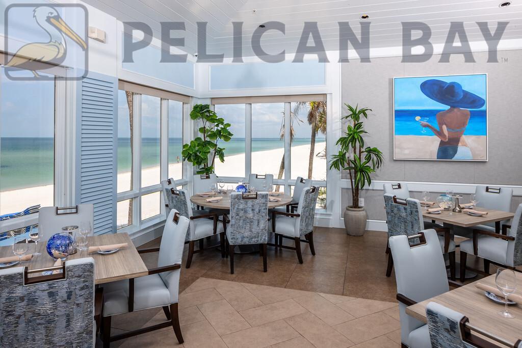 Interior of Marker 36 beachfront restaurant in Pelican Bay Naples FL with floor-to-ceiling windows and coastal artwork