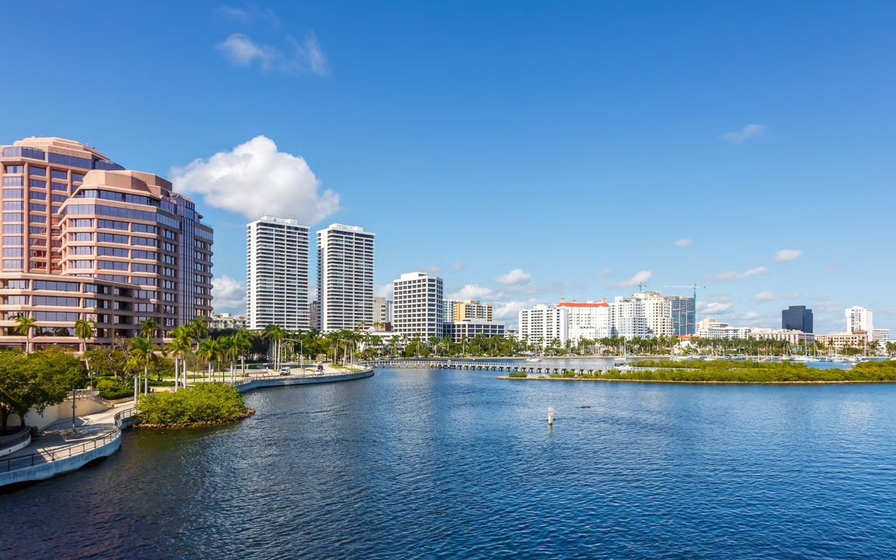 Scenic view of West Palm Beach Florida featuring luxury condos, palm-lined streets, and vibrant waterfront living