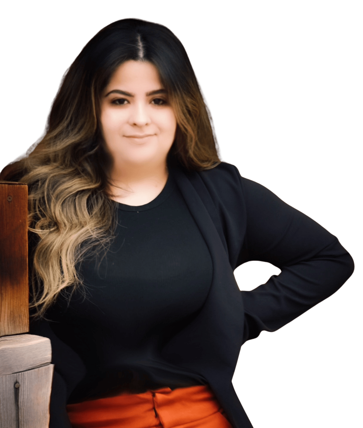 Maggie Nuno in a black blazer and top with orange trousers, leaning beside a wooden railing.