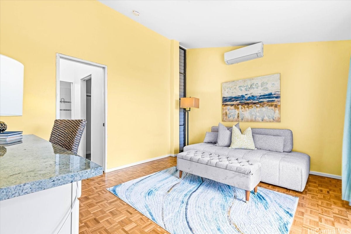 Living room with yellow walls, a gray sectional sofa, and a blue-and-white rug.