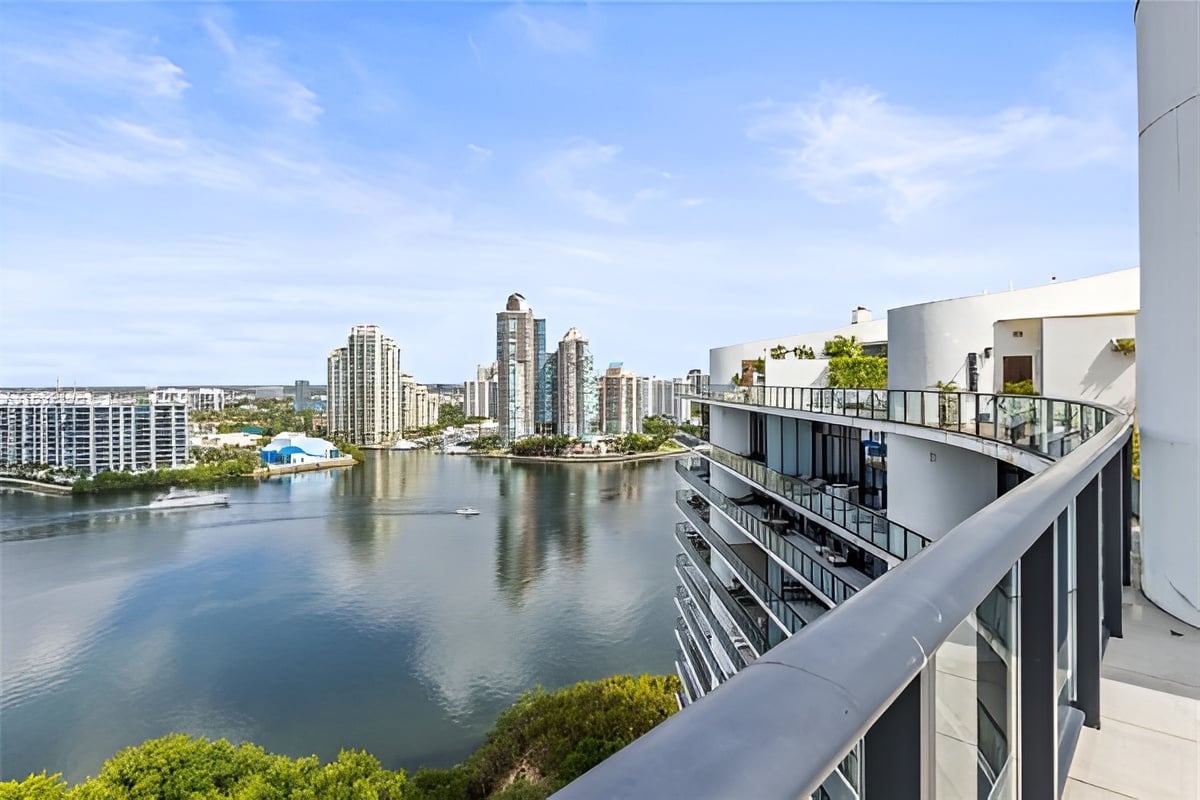 High-rise balcony overlooking calm water and modern residential towers.