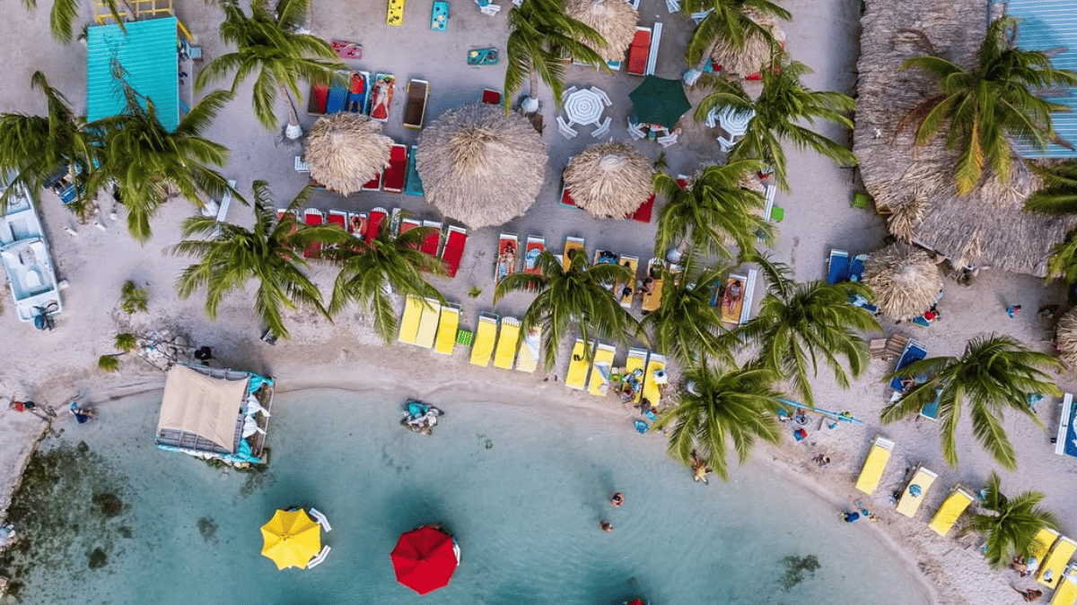 Showing beach chairs and tables in the clear water along the beach