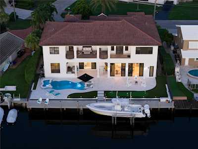 Waterfront home with a swimming pool, private dock, and boat.