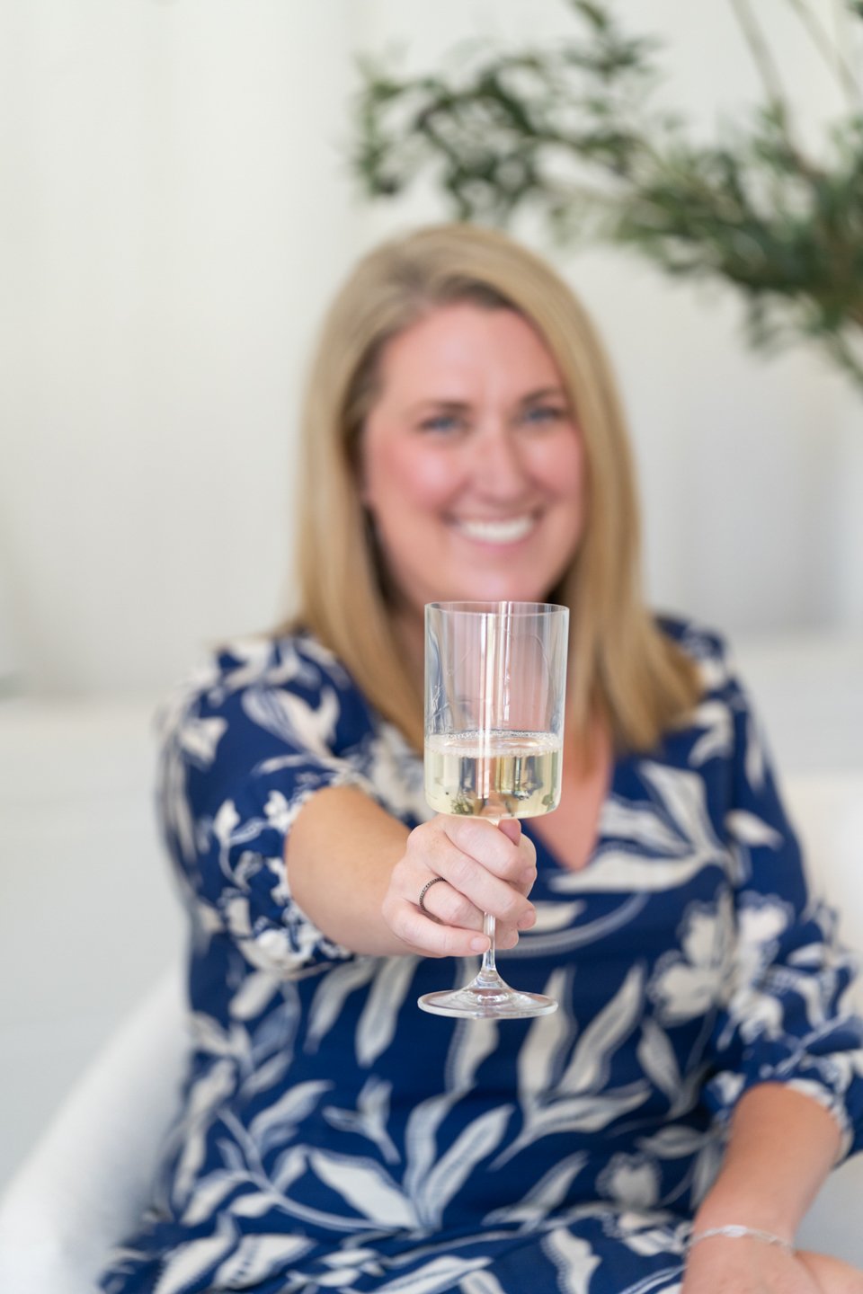 Denver real estate agent Kathryn Tighe holding a champagne glass and celebrating with first-time homebuyers.