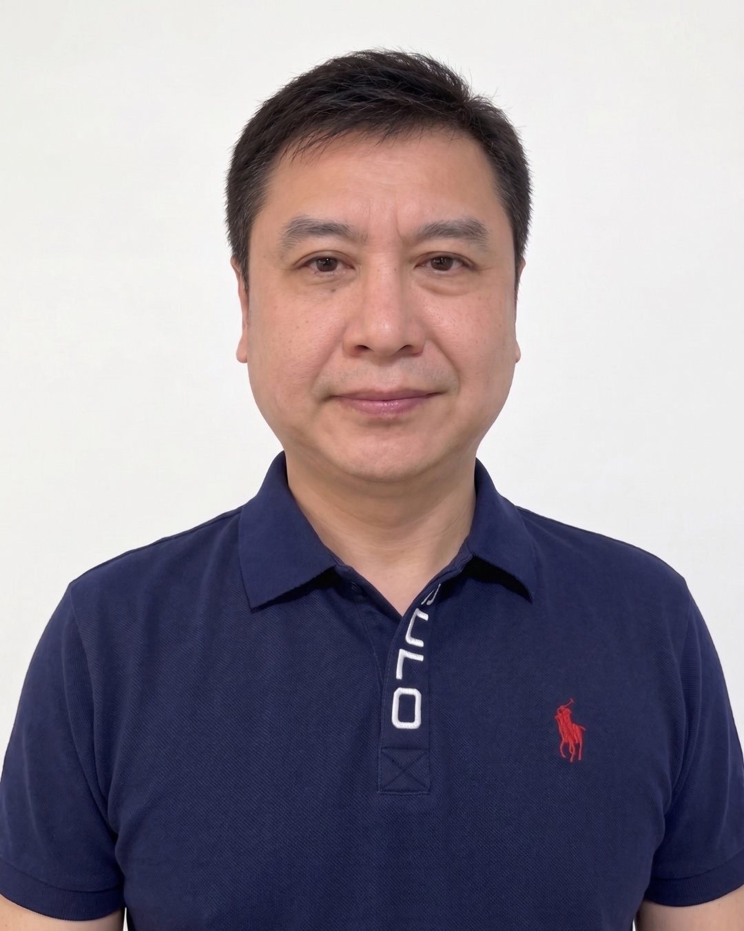 Jun Xu in a navy polo shirt against a plain white background.