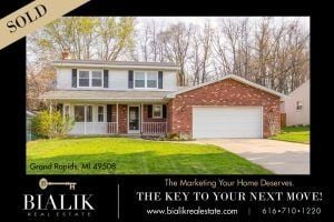 Two-story suburban home with a brick garage and a SOLD banner.