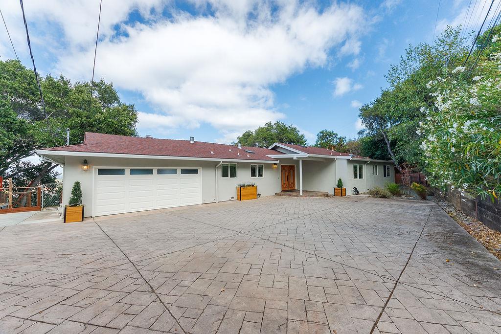 Single-story home with a three-car garage and broad stamped-concrete driveway.