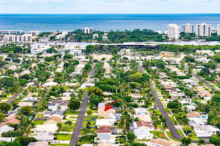 Aerial view of East Boca homes, tree-lined streets, coastal high-rises, and the Atlantic Ocean.