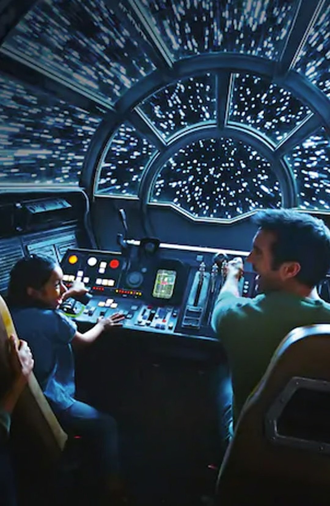 A man and child operate a futuristic spacecraft simulator together.