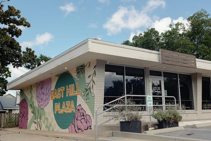 East Hill Plaza storefront with a colorful floral mural and accessibility ramp.