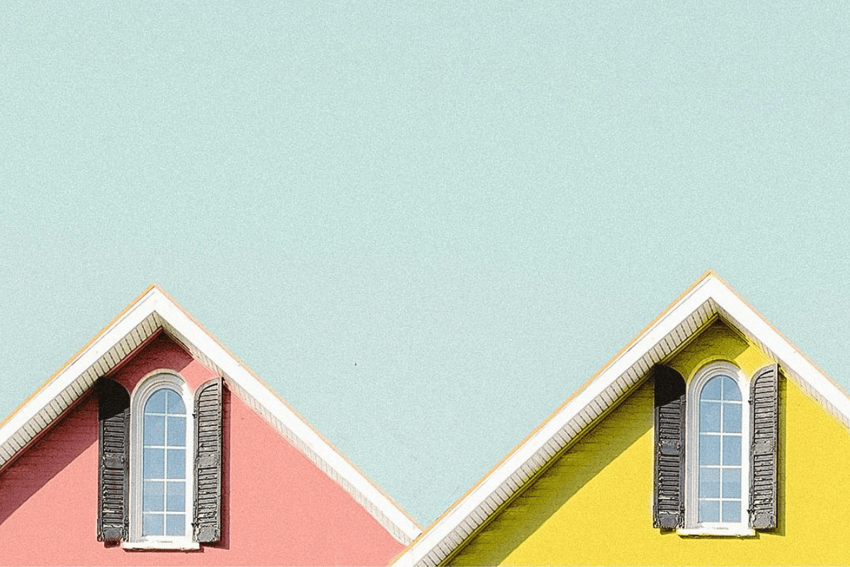 Charming pink and yellow gable homes with arched windows, inspiring first-time buyers exploring unique options in Victoria, BC.