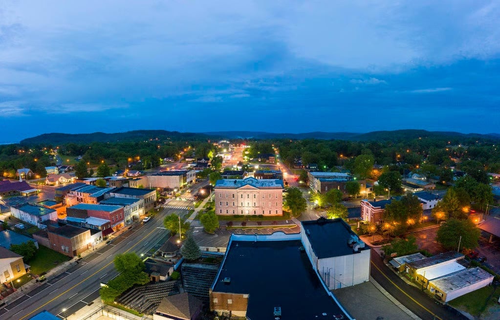 Historic brick main street in a small Tennessee town at golden hour with Cumberland Plateau bluffs behind