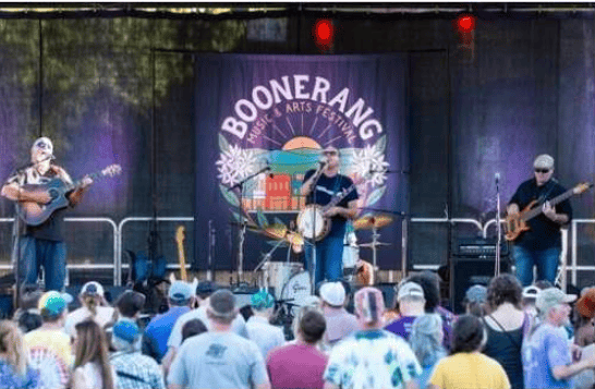 Musicians perform onstage at Boonerang Arts Festival before a crowd.