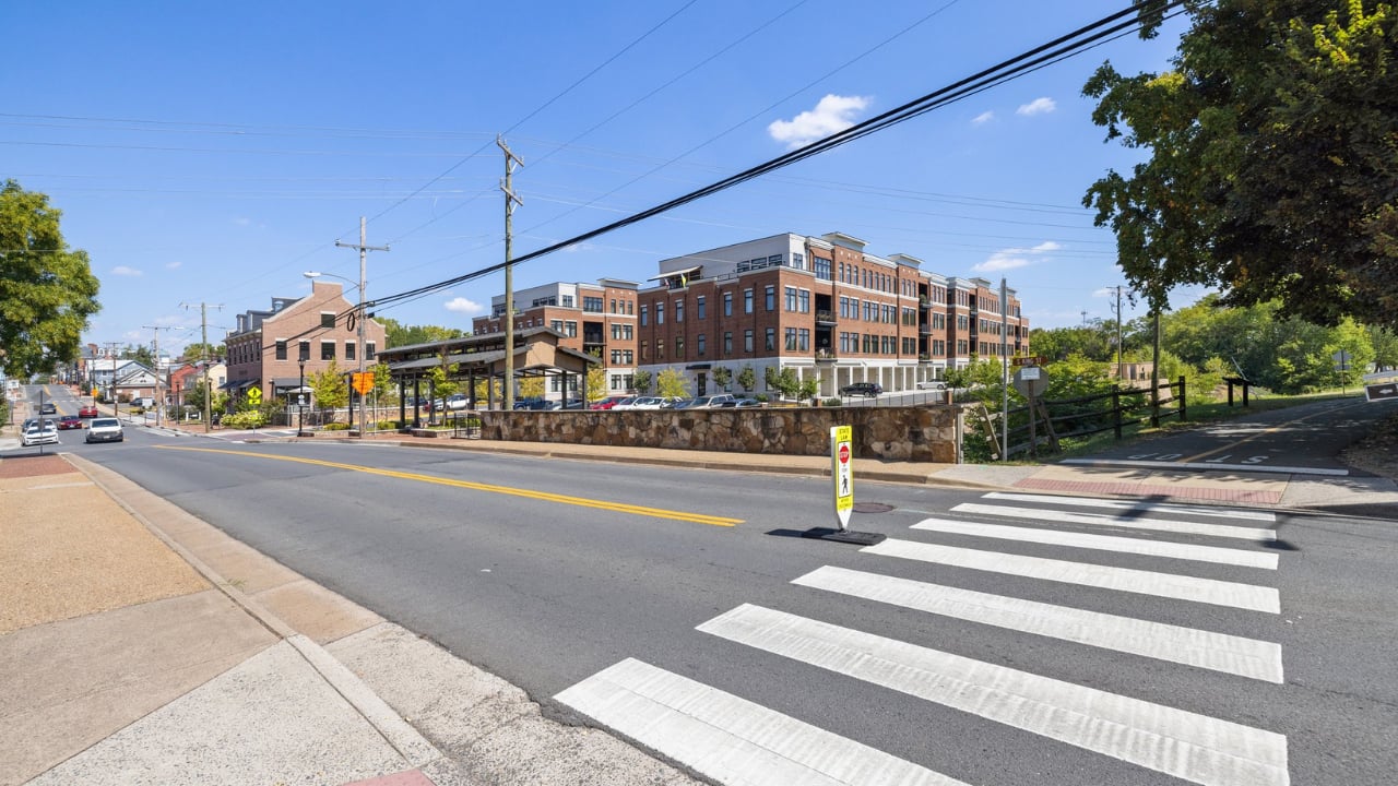 Leesburg street crossing in front of a large brick-and-white building.